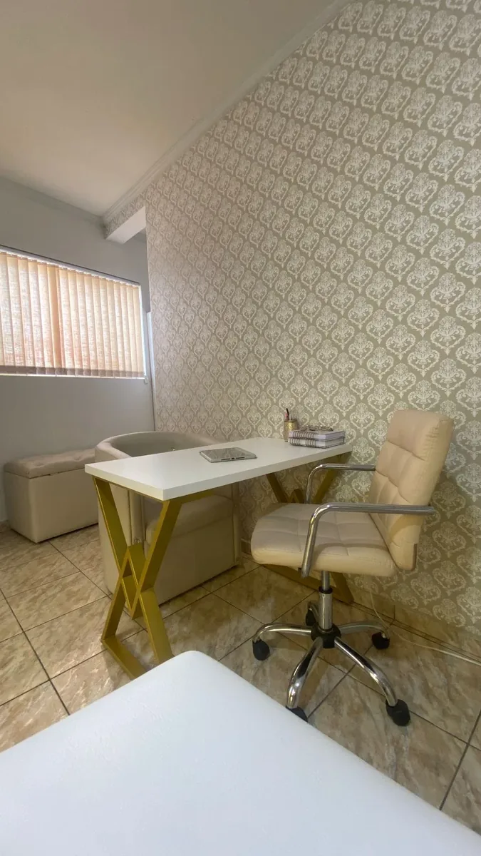 Sala de consulta com mesa dourada e cadeira bege